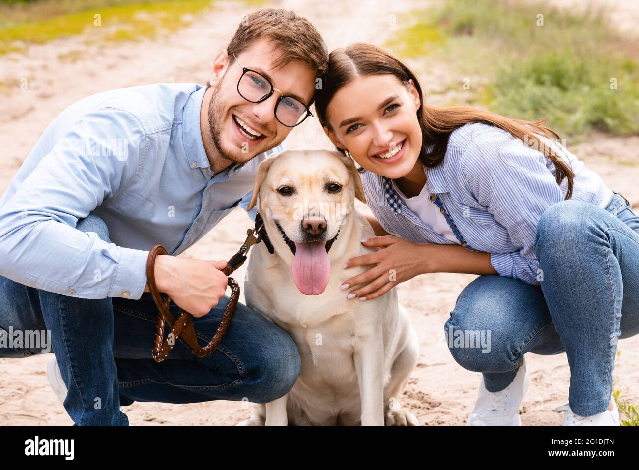 Portrait of happy young couple hugging their lovely dog Stock Photo - Alamy