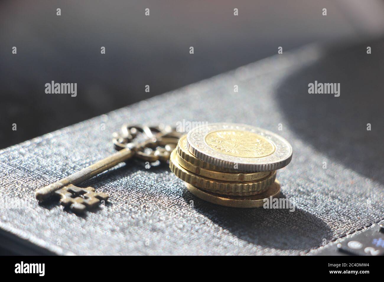 Vintage key and pile of coins. Money saving and Account Security