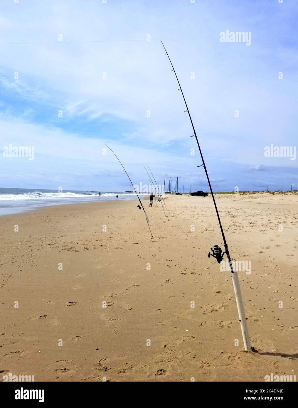 Sandy beach with surf fishing rods on a sunny day Stock Photo - Alamy