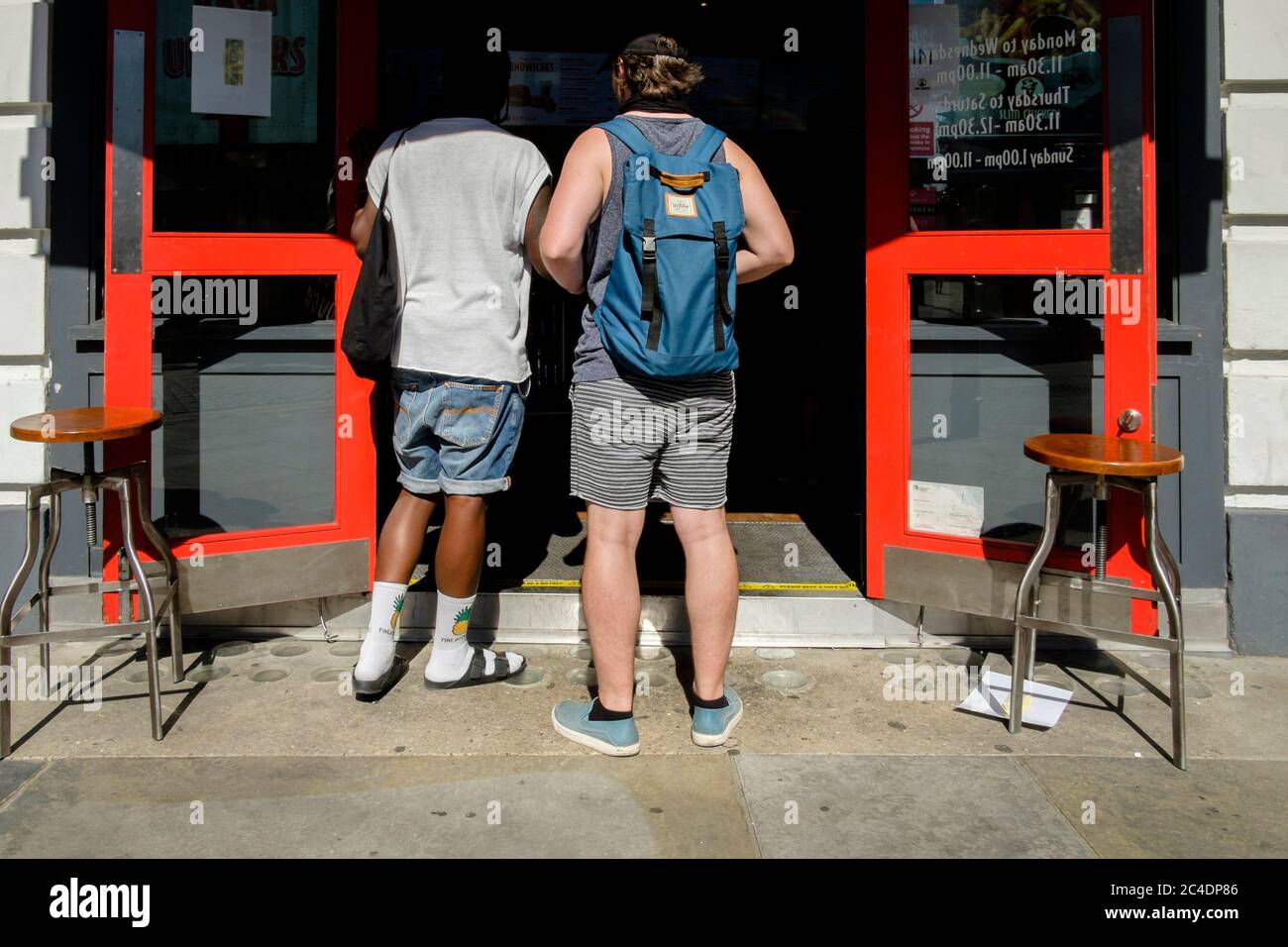 25th June 2020. Customers wait outside takeaway food outlet in central London. Stock Photo