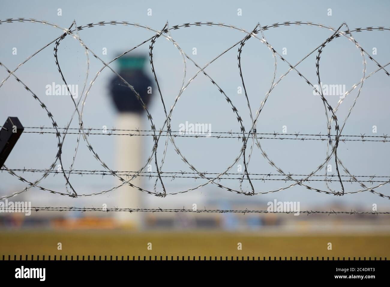 Manchester Airport air traffic control tower through barbed wire of the perimeter fence Stock Photo