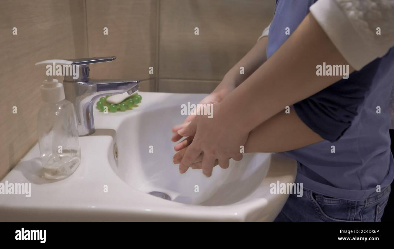 Washing hands with mother. Mom helps her son wash his hands after shopping. Hygiene concept. Pandemic concept. Close up shot Stock Photo