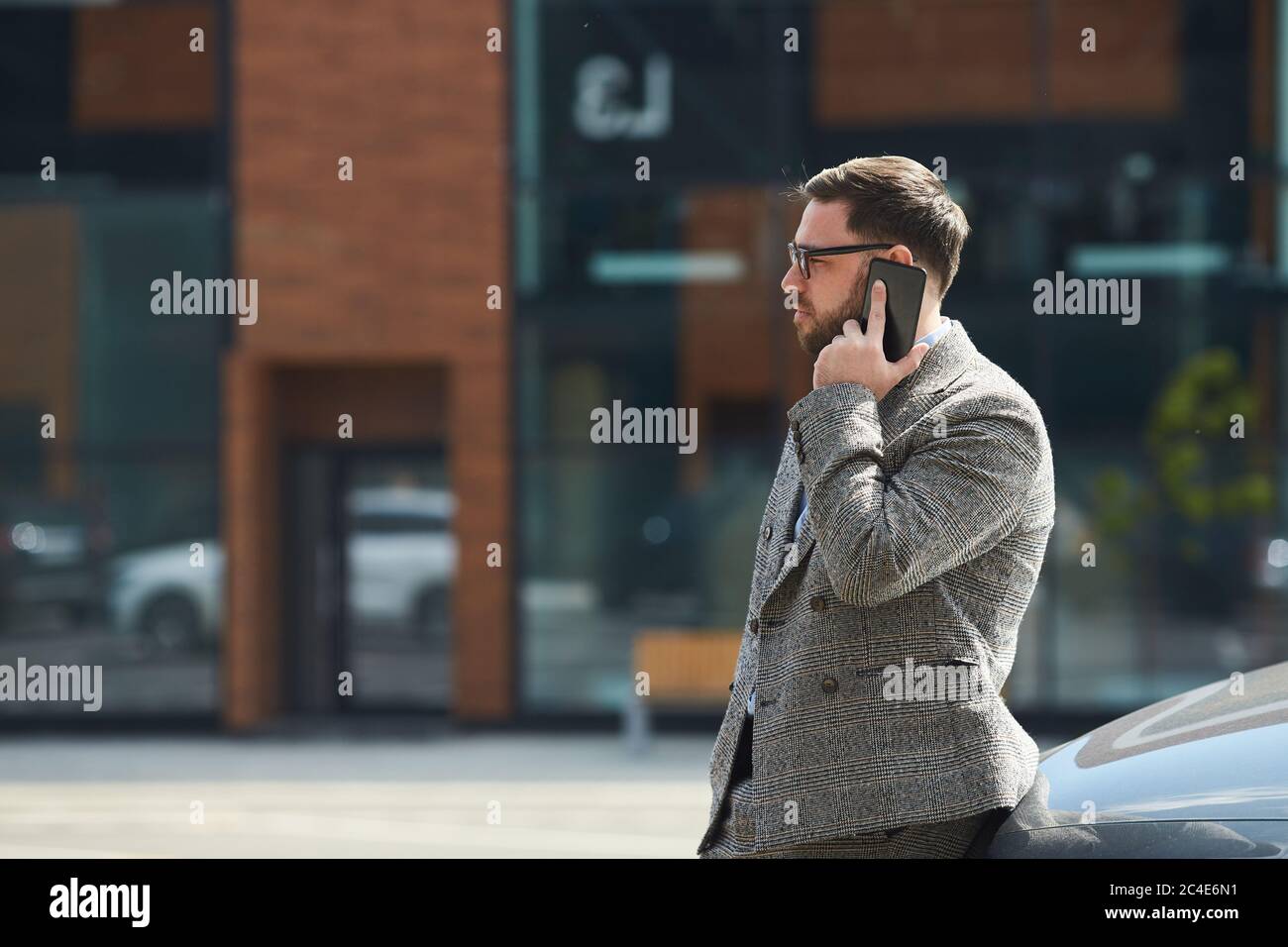 Young man talking on mobile phone while standing outdoors in the city Stock Photo