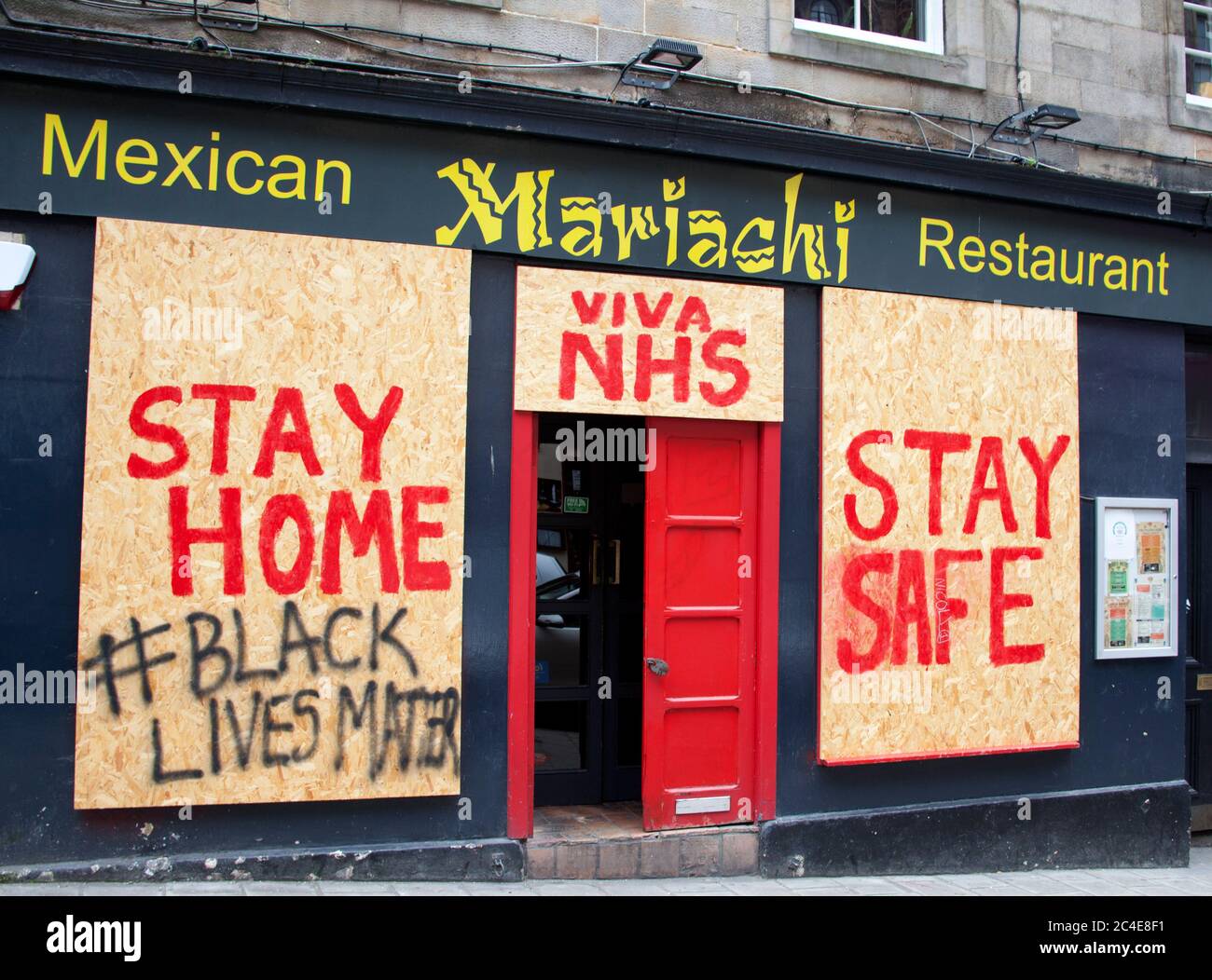 Edinburgh, Scotland, UK. 26 June 2020. Some city centre pubs and restaurants are still boarded up as they were at the beginning of the Pandemic crisis in Scotland, but others are showing some signs of life such as painting and decoration and perhaps alterations to meet the new requirements of social distancing. Pictured: Mariachi Mexican Restaurant  in Victoria Street, which has the door ajar but reamains boarded up. Stock Photo