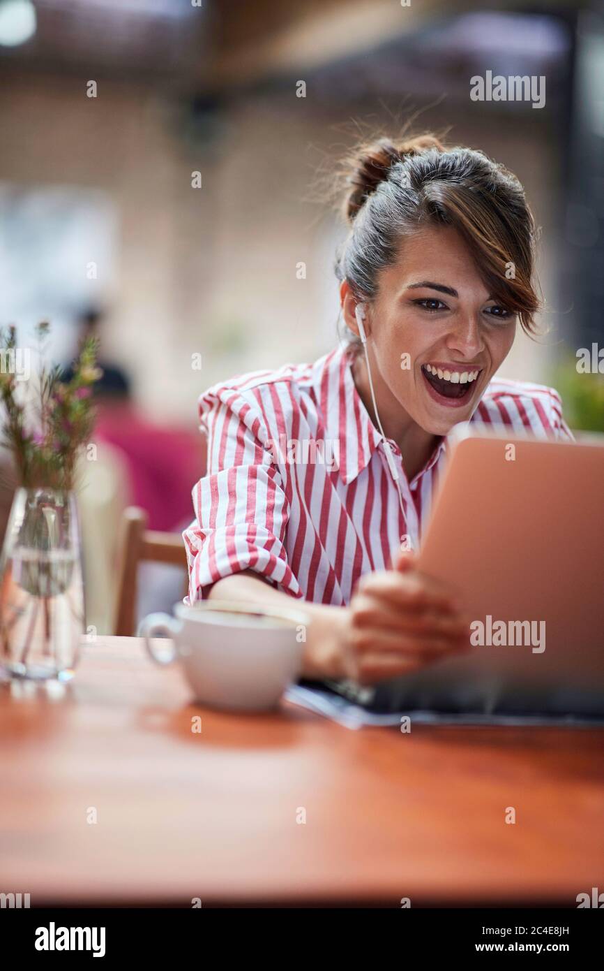 gorgeous young caucasian female, smiling, delighted with content on laptop Stock Photo