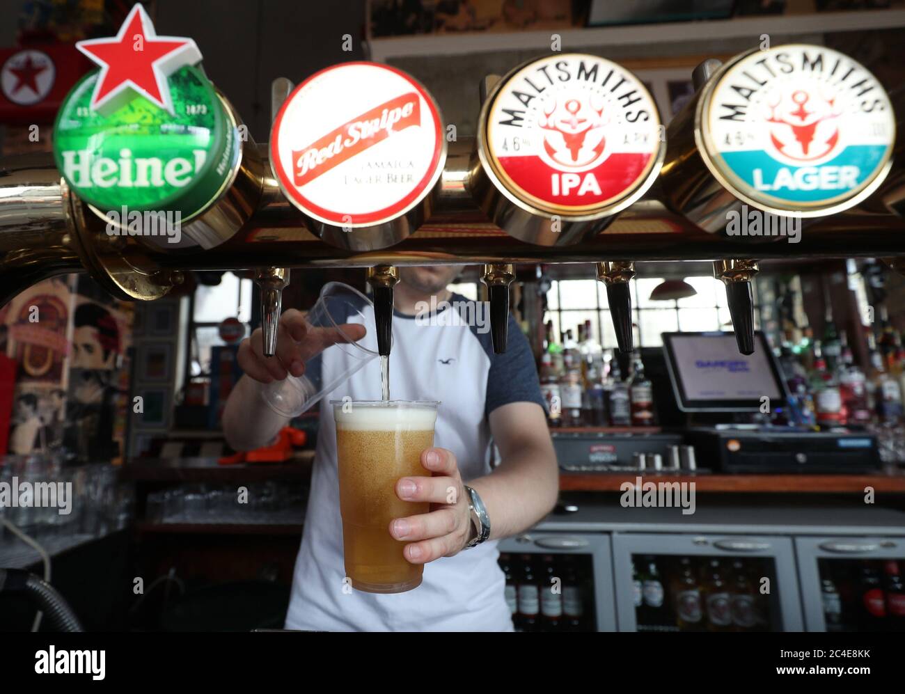 A barman serving takeaway drinks at Charrington's Noted Ales And Stout pub in London, as further coronavirus lockdown restrictions are lifted in England. Stock Photo