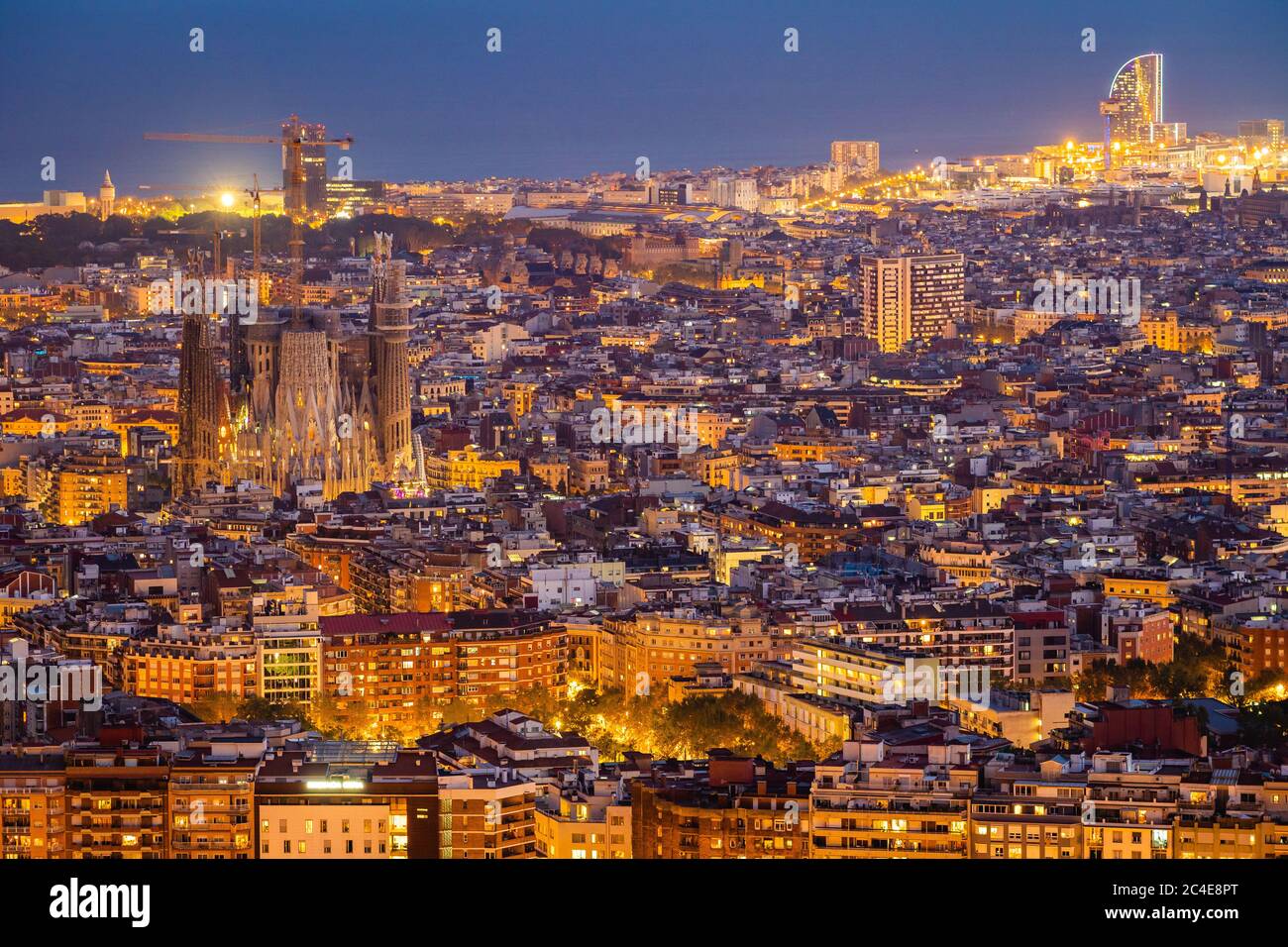 Aerial view of Barcelona cityscape including architectural landmark Sagrada Familia basilica illuminated at dusk, Catalonia, Spain. Stock Photo