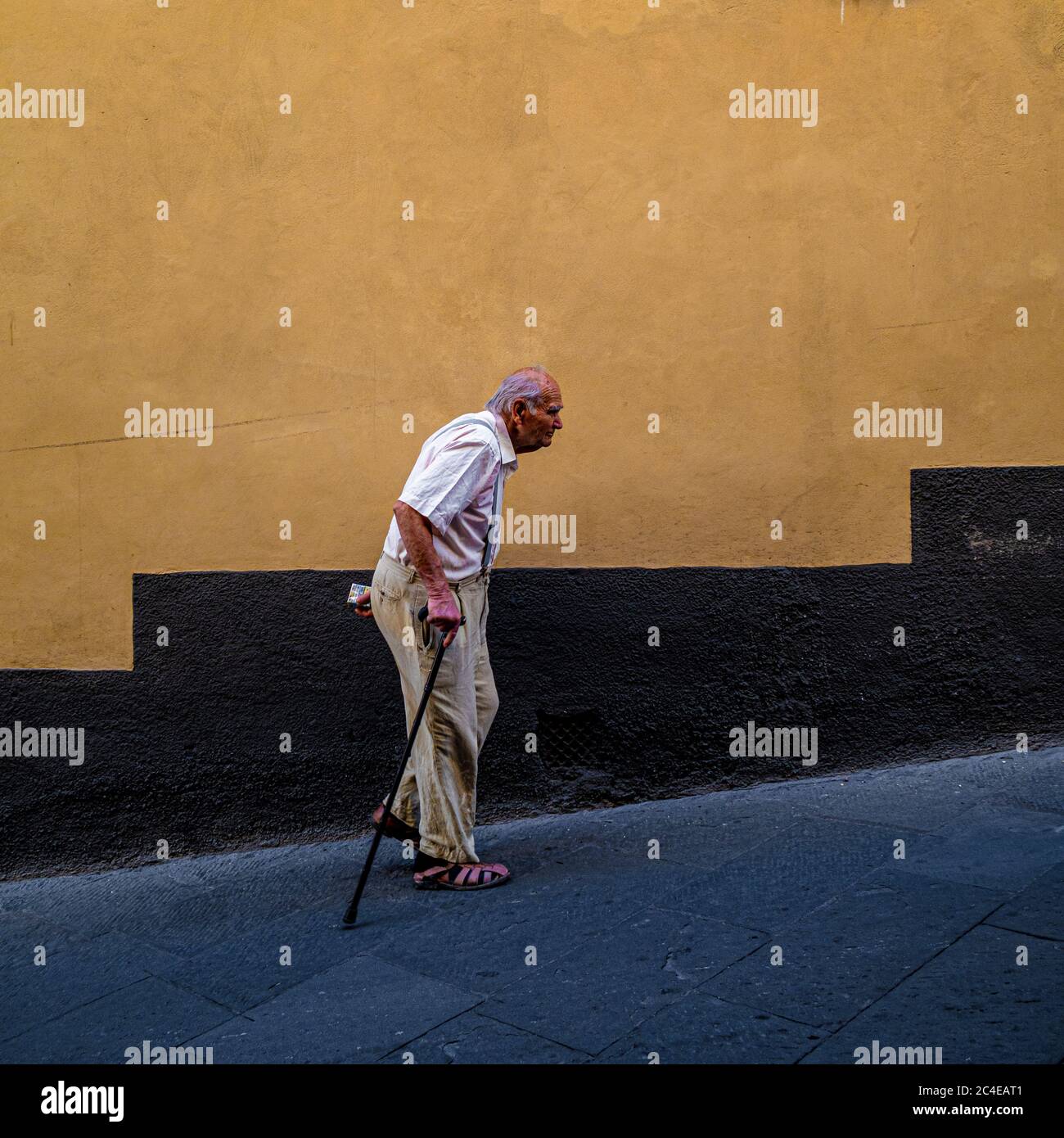 Elderly local man walking up a steep foot street in Siena. Italy. Stock Photo