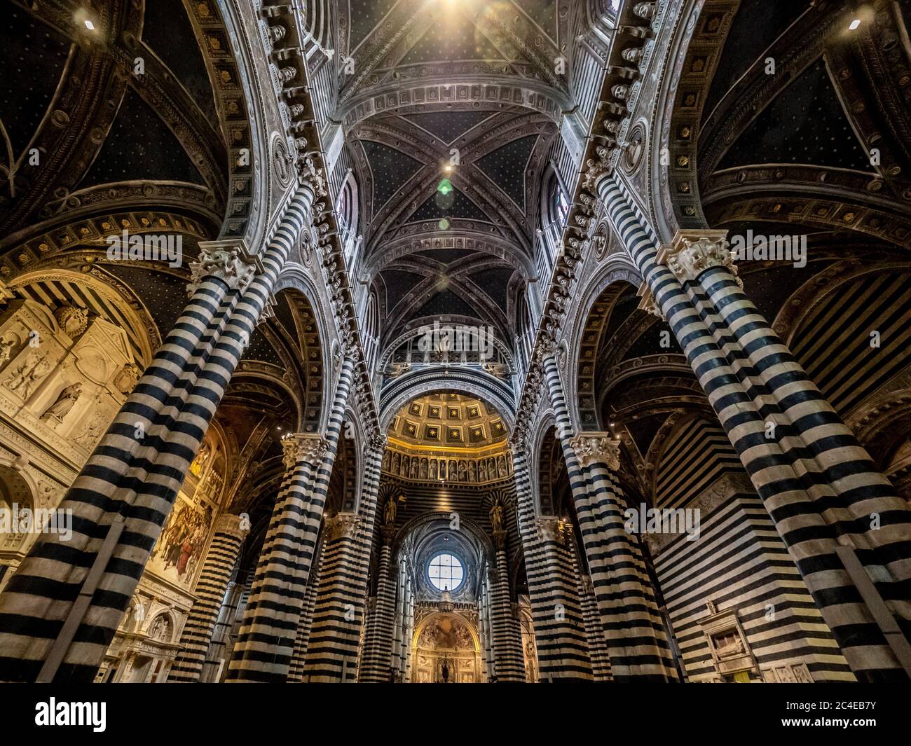 Interior view of central ceiling supported by black and white marble pillars. Siena Cathedral. Italy. Stock Photo