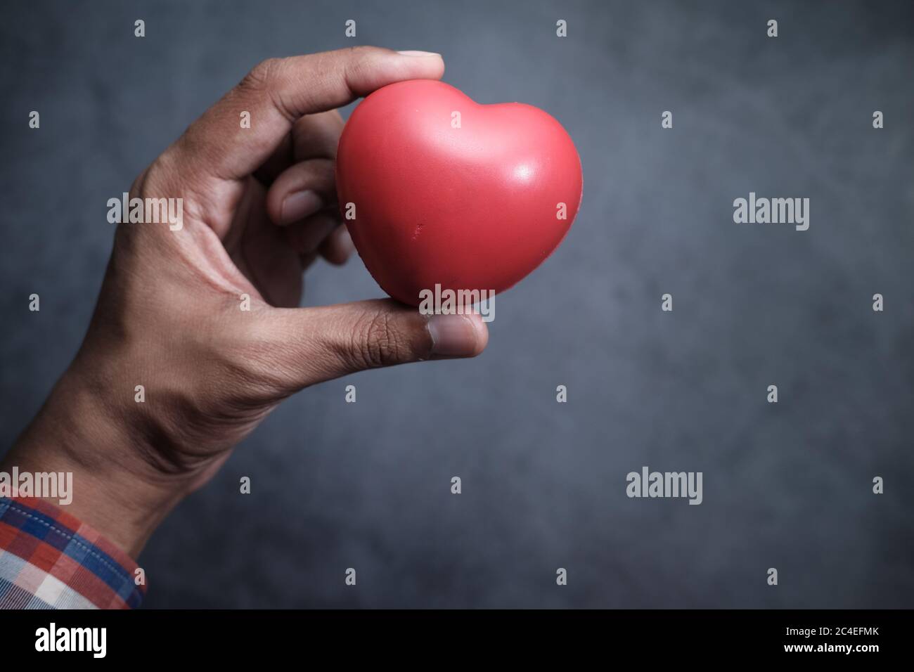 man holding red heart in hands Stock Photo - Alamy