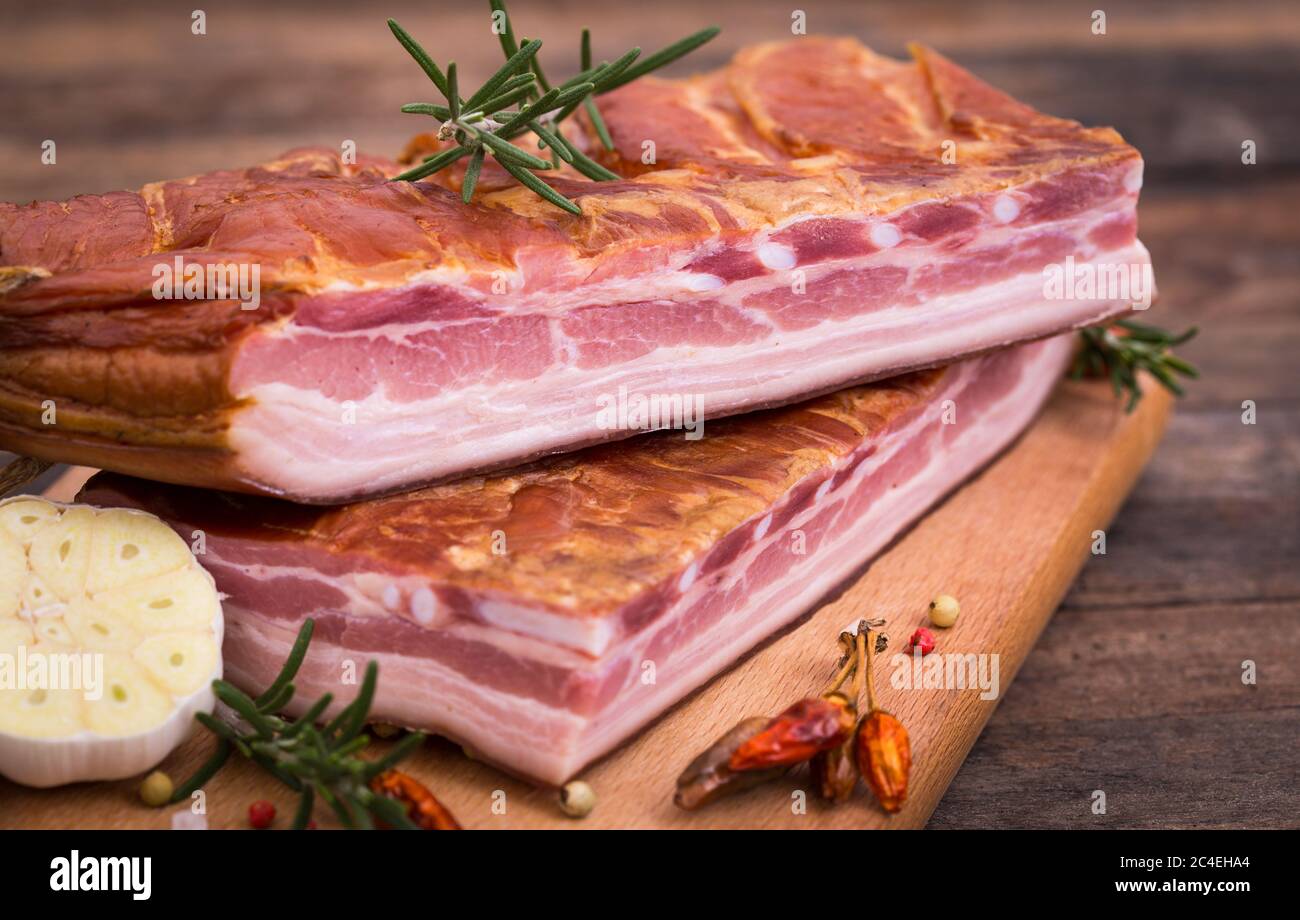 Homemade smoked bacon on wooden board Stock Photo