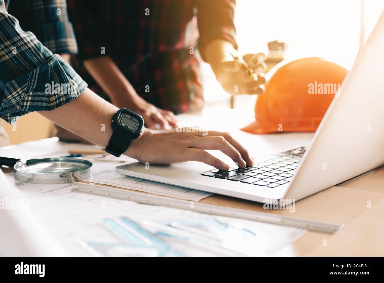 Two architects co-worker working together on project and using laptop checking data about construction. Stock Photo