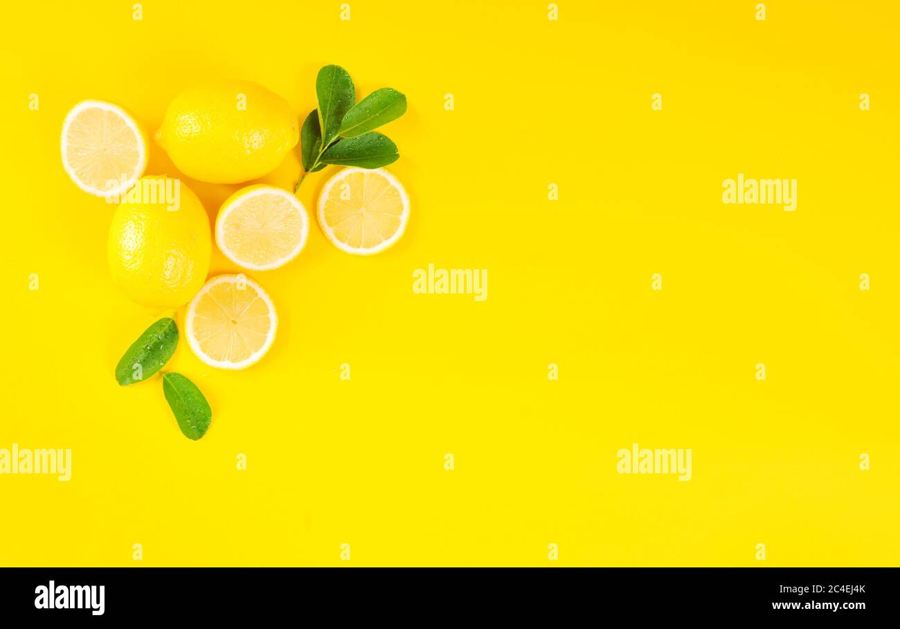 Lemons and green leaves on bright yellow background. Lemon background  concept, flat lay. Lemon fruit, citrus minimal concept. Creative background  made Stock Photo - Alamy