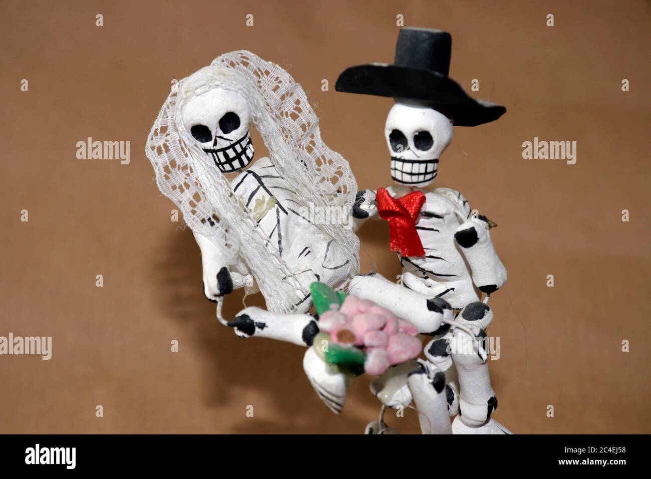 Miniature clay figurines of skeleton bride and groom dressed for
