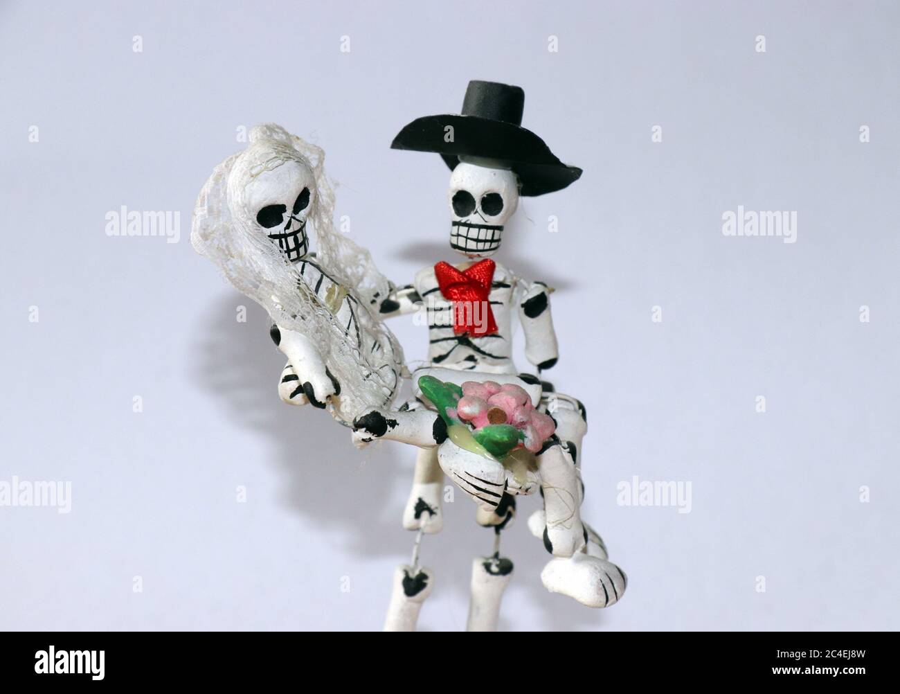 Miniature clay figurines of skeleton bride and groom dressed for