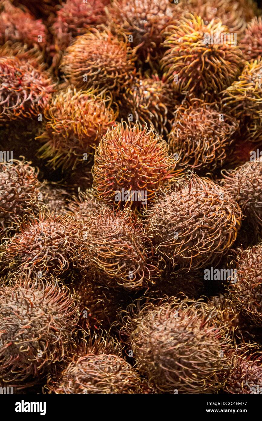 A full frame photograph of rambutan fruit for sale on a market stall Stock Photo