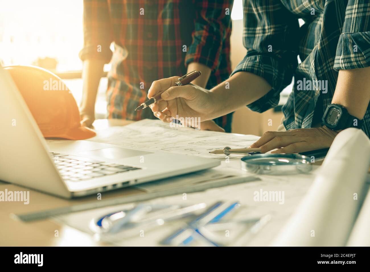 Two architects working together on project and using laptop checking data about construction. Stock Photo