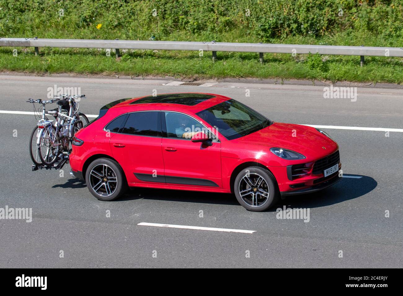 2019 red Porsche Macan S-A  five-door luxury crossover SUV; Vehicular traffic moving vehicles, cars driving vehicle on UK roads, motors, motoring on the M6 motorway highway network. Stock Photo