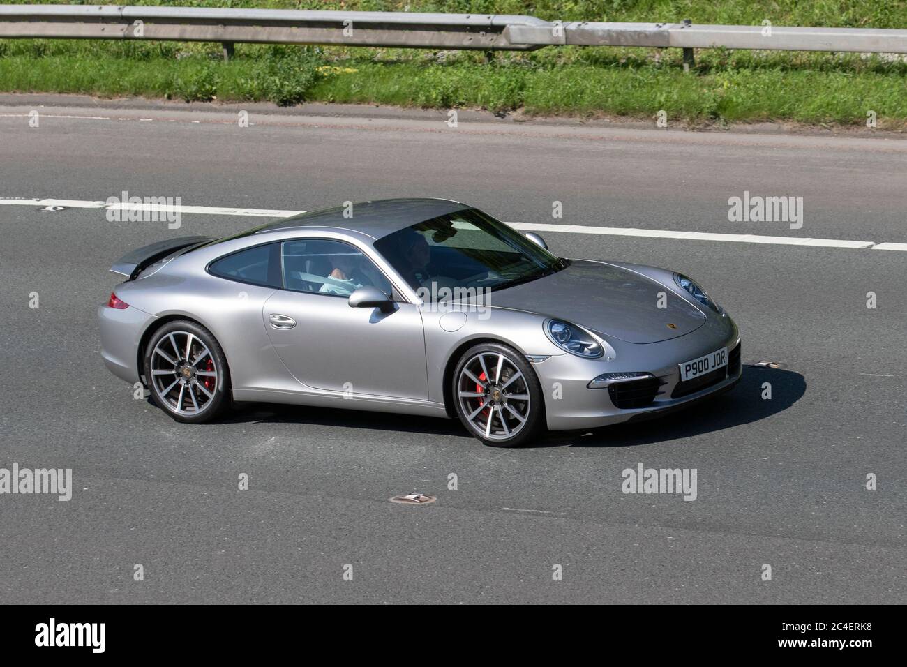 2012 silver grey Porsche 911 Carrera S S-A; Vehicular traffic moving vehicles, cars driving vehicle on UK roads, motors, motoring on the M6 motorway highway network. Stock Photo