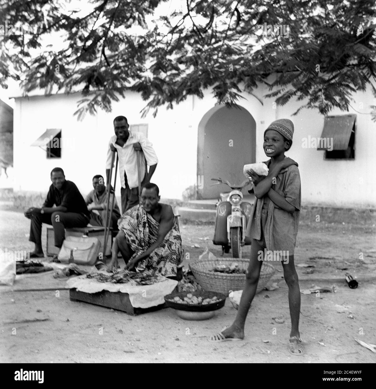 Men and a boy selling food and souvenirs in the Ivory Coast 1963 Cote d'Ivoire Ivory Coast 1960s Stock Photo