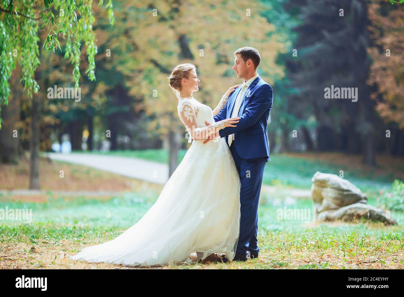 Bride and groom in the park kissing. wedding in nature green forest ...