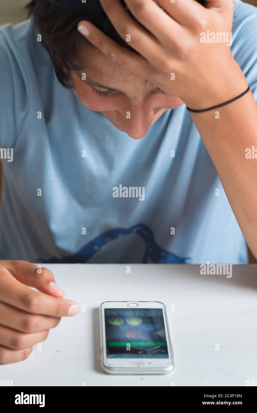 Teenage boy chats with friends on his smart phone Stock Photo