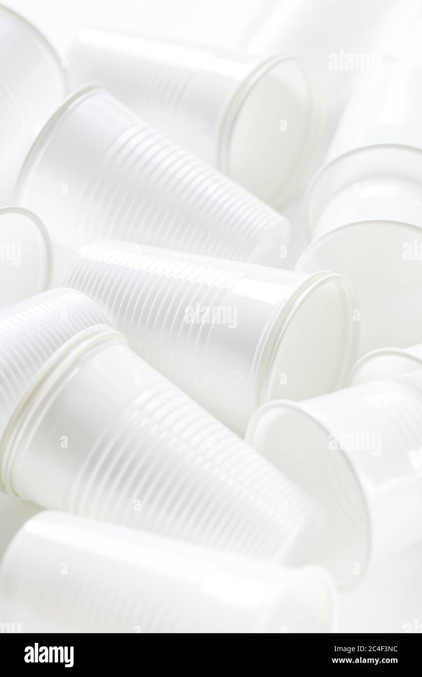 Disposable white plastic cups as background. Environmental concept. Non-compostable waste. Stock Photo