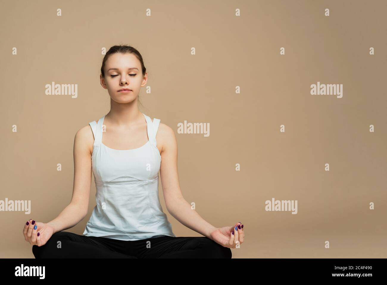 A girl sits in a lotus position and meditates with her eyes closed. Zen ...