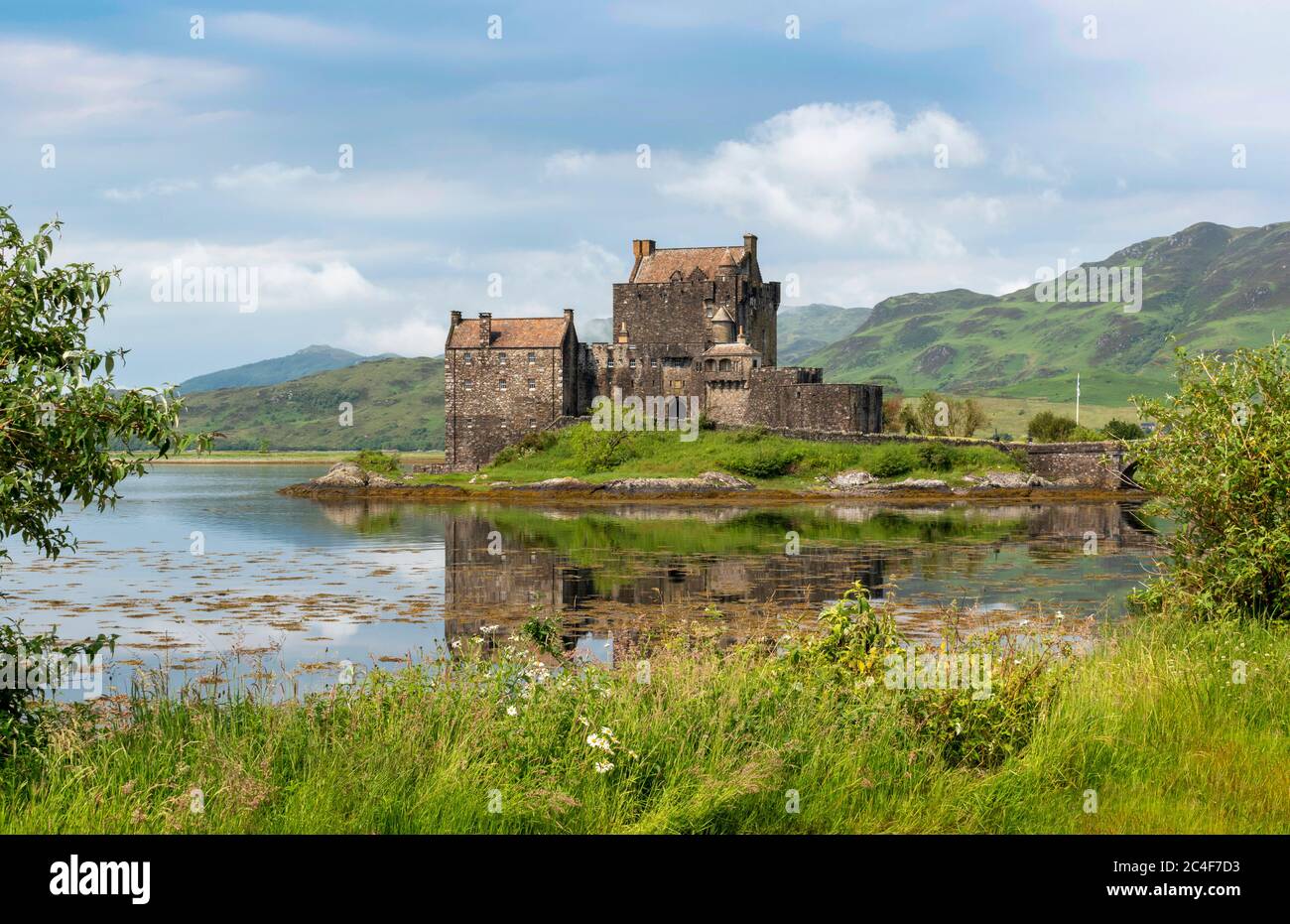 EILEAN DONAN CASTLE LOCH DUICH HIGHLAND SCOTLAND CASTLE ON AN ISLAND FLOWERS AND GRASSES IN JUNE Stock Photo
