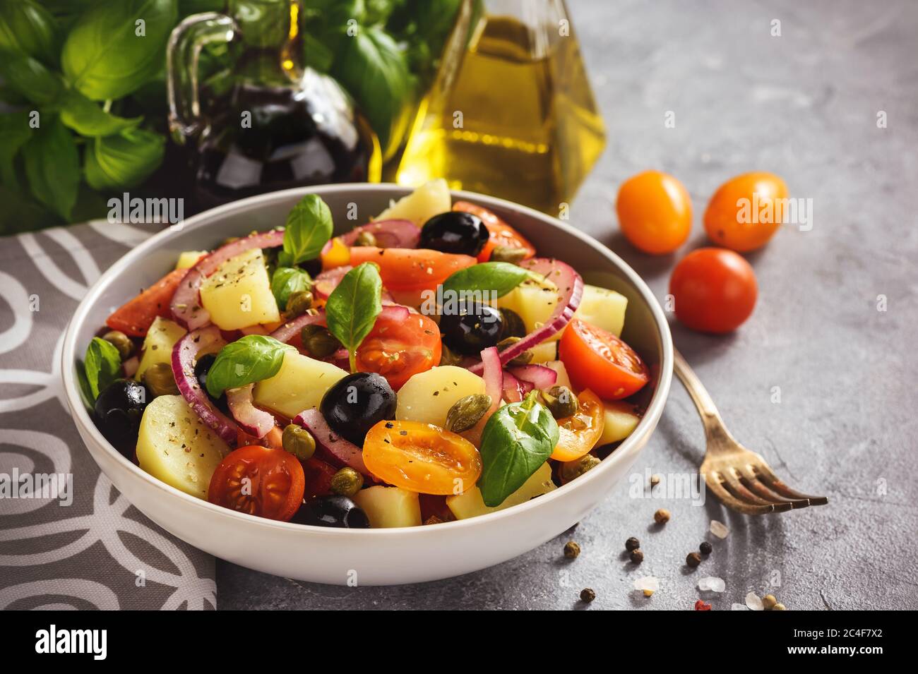 Potato salad with tomatoes, olives, capers, red onion, italian style cuisine. Insalata Pantesca. Stock Photo