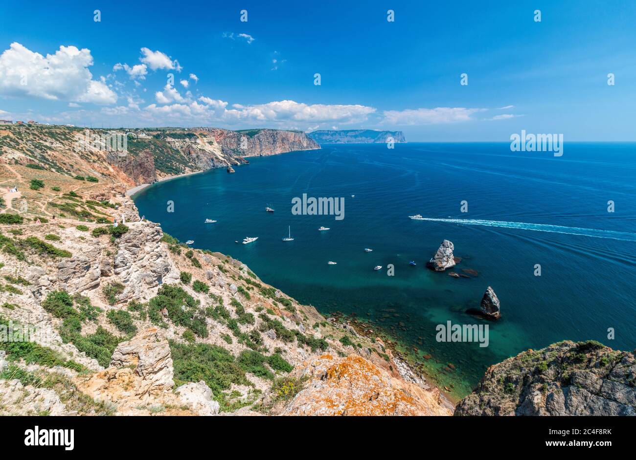 Sea bay from the height of overhanging cliffs. Cape Fiolent in Balaklava, Sevastopol, Crimea. Bright sunny day, crystal clear blue sea with yachts Stock Photo