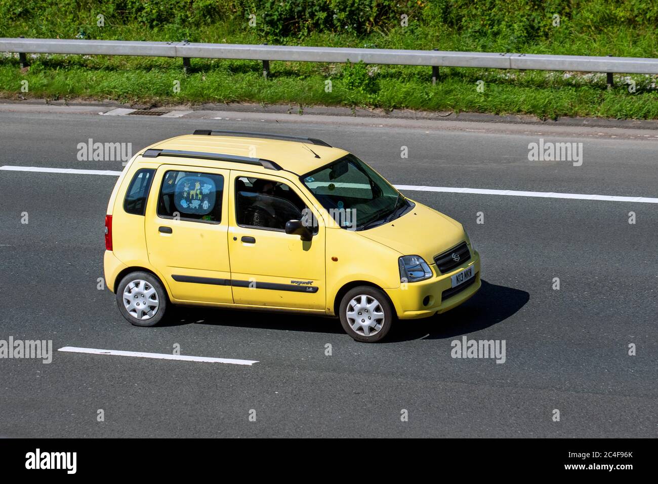 2004 yellow Suzuki Wagon R 1.3 VVT 16V GL 5dr ESTATE Petrol Manual; Vehicular traffic moving vehicles, cars driving vehicle on UK roads, motors, motoring on the M6 motorway highway network. Stock Photo