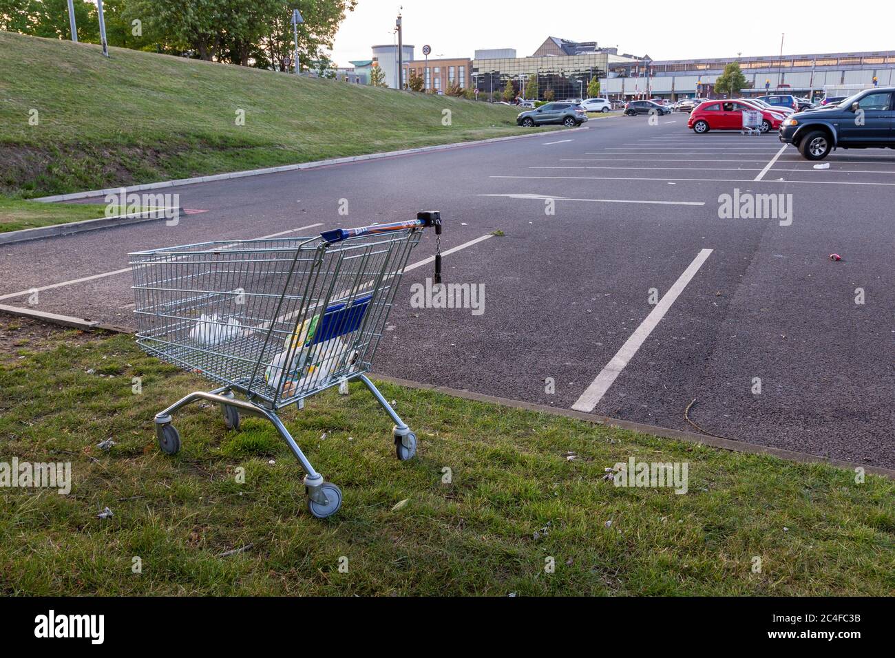 Shopping trolley or cart abandoned on a shopping centre car park UK Stock Photo
