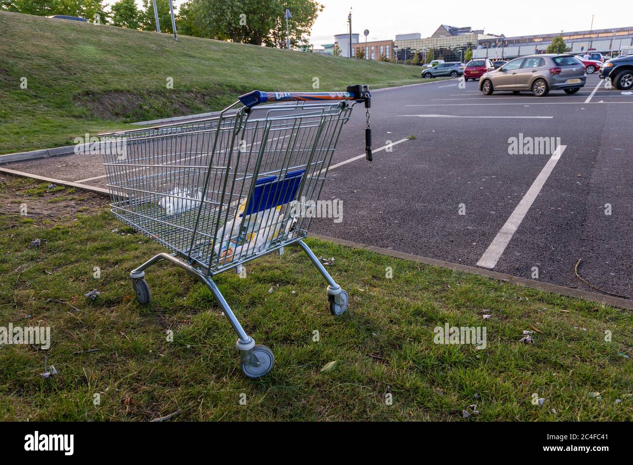 Shopping trolley or cart abandoned on a shopping centre car park UK Stock Photo