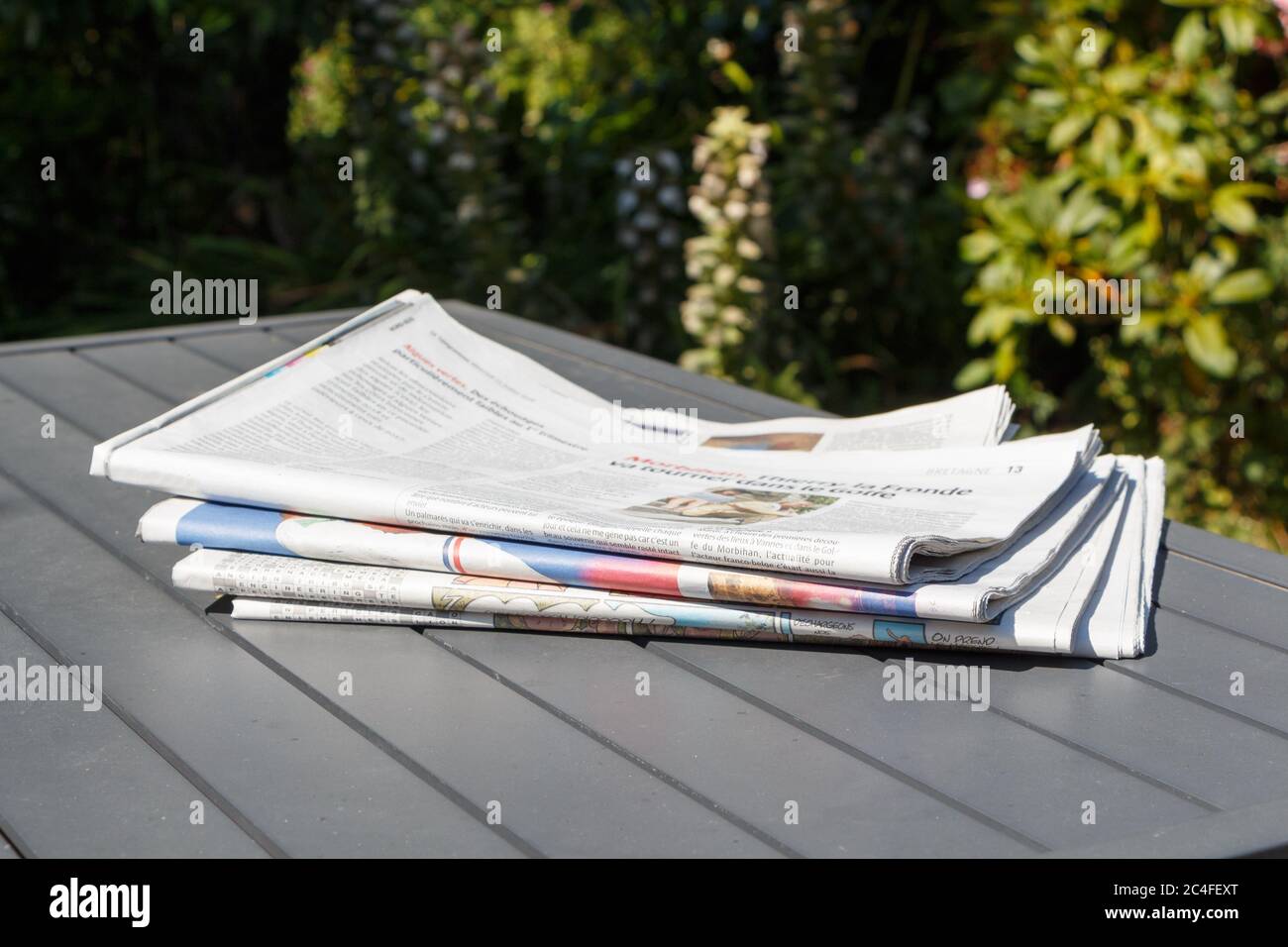 Pile of newspapers on a table in a garden Stock Photo Alamy