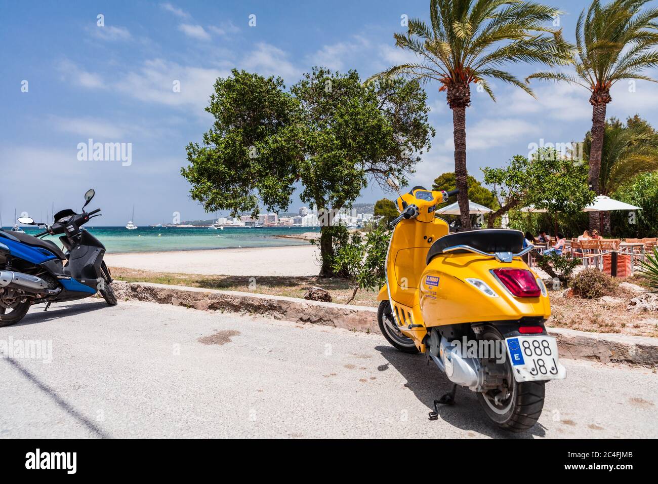 Scooters parked by the sunny beach and restaurant in Ibiza, Spain Stock  Photo - Alamy
