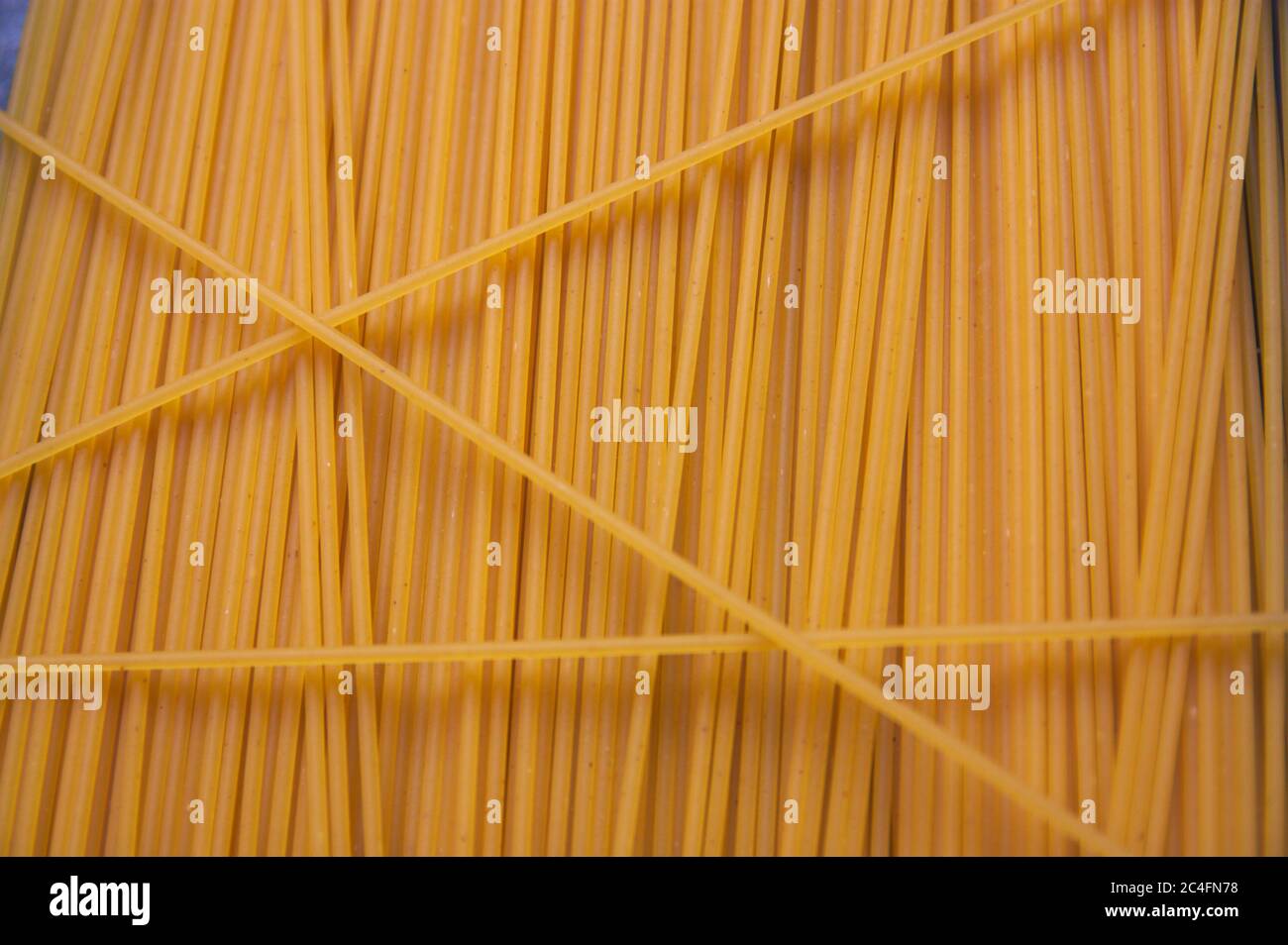 Dried egg spaghetti form a texture with a vertical line pattern useful for gastronomic backgrounds Stock Photo