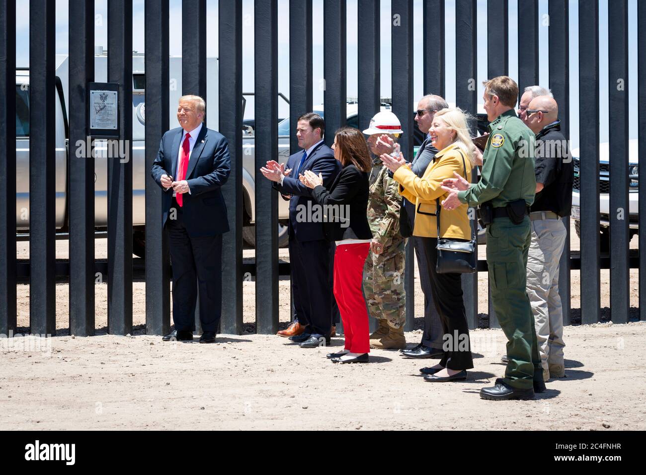 U.S. President Donald Trump along with Acting DHS Secretary Chad Wolf and Acting CBP Commissioner Mark Morgan, applaud after placing a plaque on a new section of border wall along the Mexican-American border June 23, 2020 in San Luis, Arizona. The visit marked the completion of 200 miles of border wall, the majority of which is replacement for existing structure at a cost of $20-million dollars a mile. Stock Photo