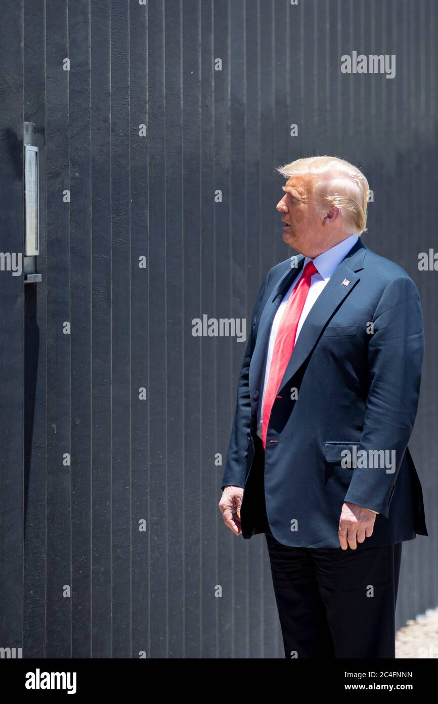 U.S. President Donald Trump reads a plaque on a new section of border wall during a visit to the Mexican-American border June 23, 2020 in San Luis, Arizona. The visit marked the completion of 200 miles of border wall, the majority of which is replacement for existing structure at a cost of $20-million dollars a mile. Stock Photo