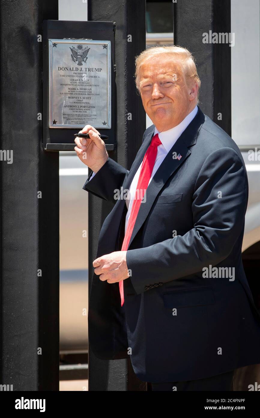U.S. President Donald Trump smiles as he signs a plaque on a new section of border wall during a visit to the Mexican-American border June 23, 2020 in San Luis, Arizona. The visit marked the completion of 200 miles of border wall, the majority of which is replacement for existing structure at a cost of $20-million dollars a mile. Stock Photo