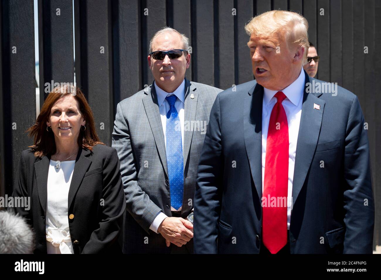 U.S. President Donald Trump tours a new section of border wall along the Mexican-American border with Senator Martha McSally, left, and Acting Commissioner Mark Morgan, June 23, 2020 in San Luis, Arizona. Stock Photo