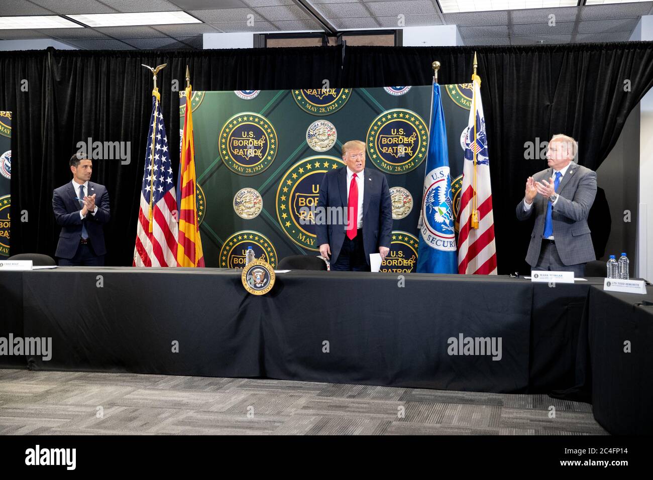 U.S. President Donald Trump is applauded by DHS Acting Secretary Chad Wolf, left, and Acting Commissioner Mark Morgan during a roundtable discussion on border security June 23, 2020 in Yuma, Arizona. Stock Photo