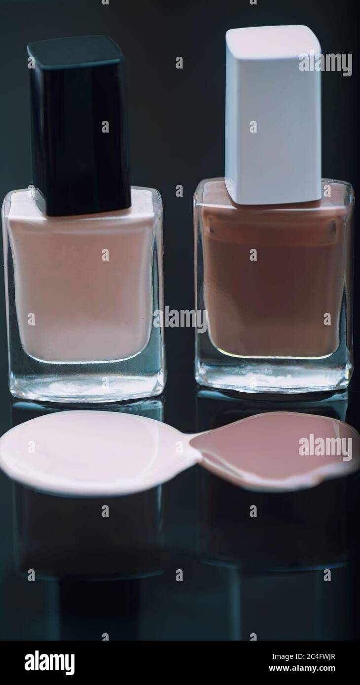 Nail polish bottles with reflection on a dark background. Stock Photo
