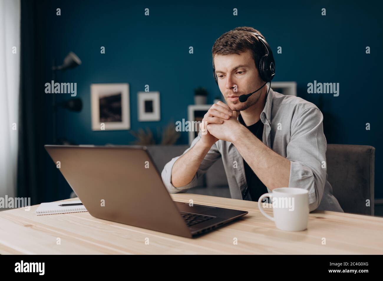 Confident man wearing headset during video chat on laptop Stock Photo
