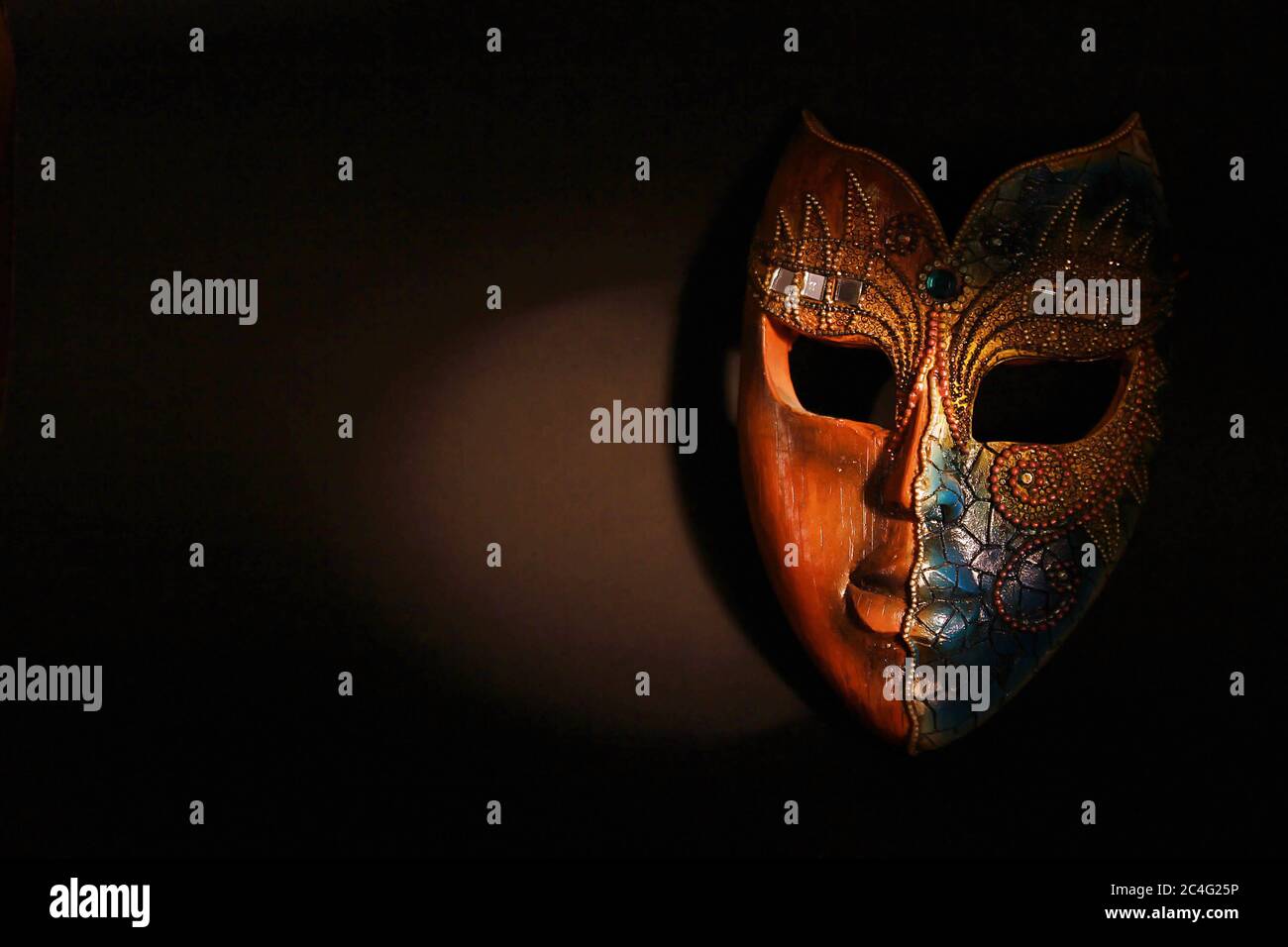 Beautiful Brown Wood Mask With Gems And Designing On It In Dramatic Spot Light Stock Photo