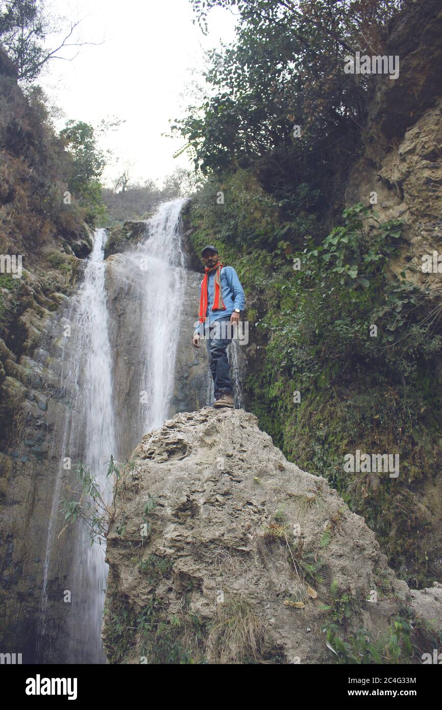 Traveler standing on a rock near waterfall in azad Kashmir, Pakistan Stock Photo
