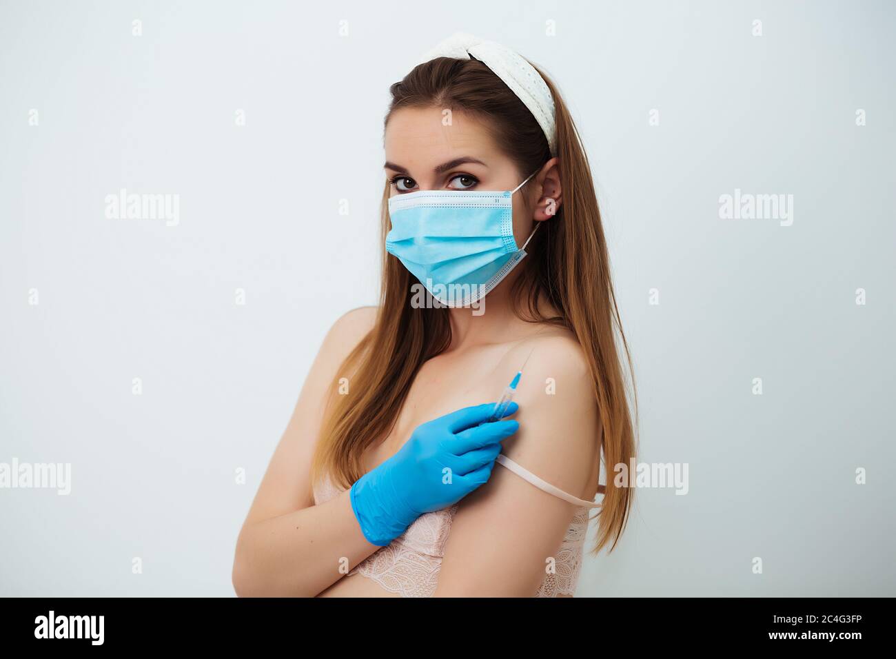 doctor girl with dark hair wearing blue gloves and medical mask on white  studio background and holding syringe, portrait, beauty treatment, close up  Stock Photo - Alamy