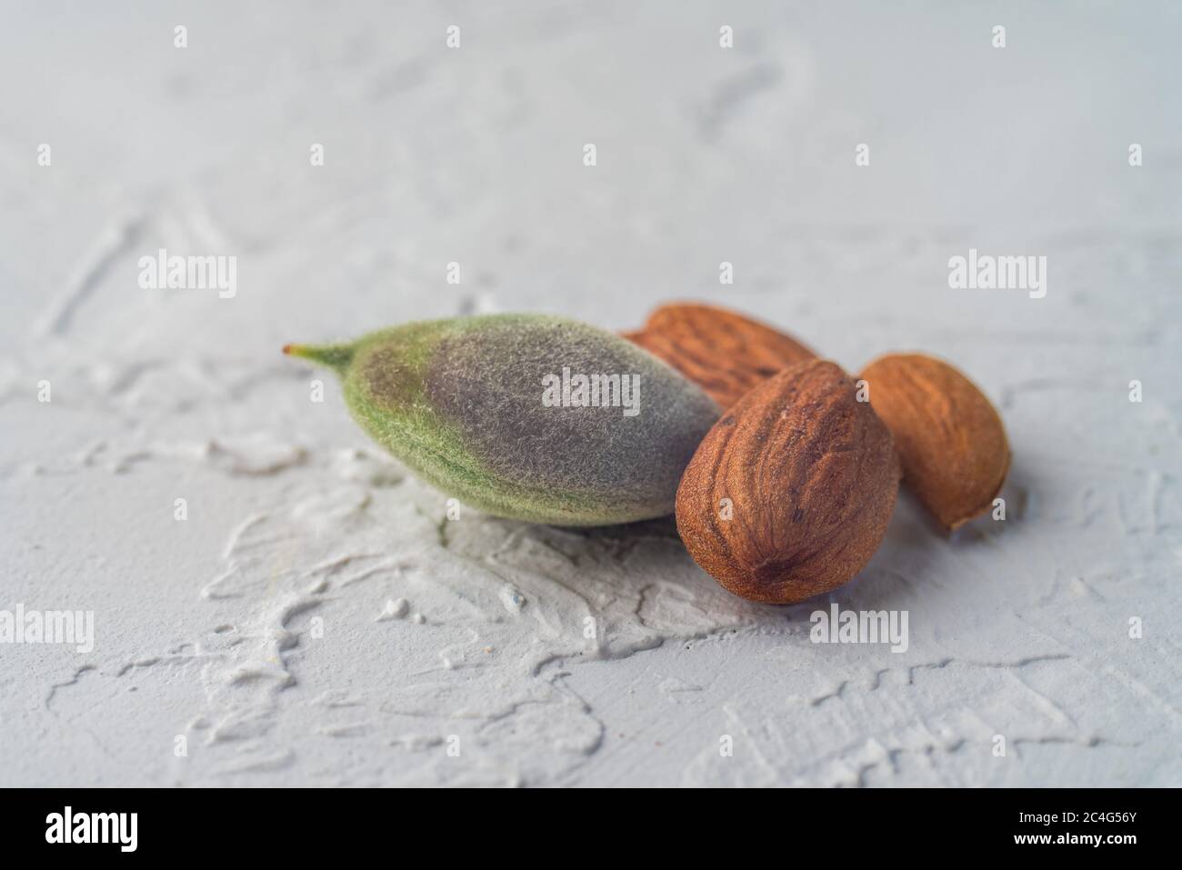 green and old riped almonds nut on spring, isolated on white textured background. Copy space. Balanced diet vegan healthy lifestyle concept. Creative Stock Photo