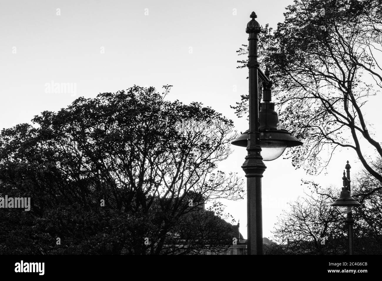 Monochrome (black and white) image of iron lamp-post and Edinburgh Old Town, from Waverley Bridge, Edinburgh, Scotland, United Kingdom. Stock Photo