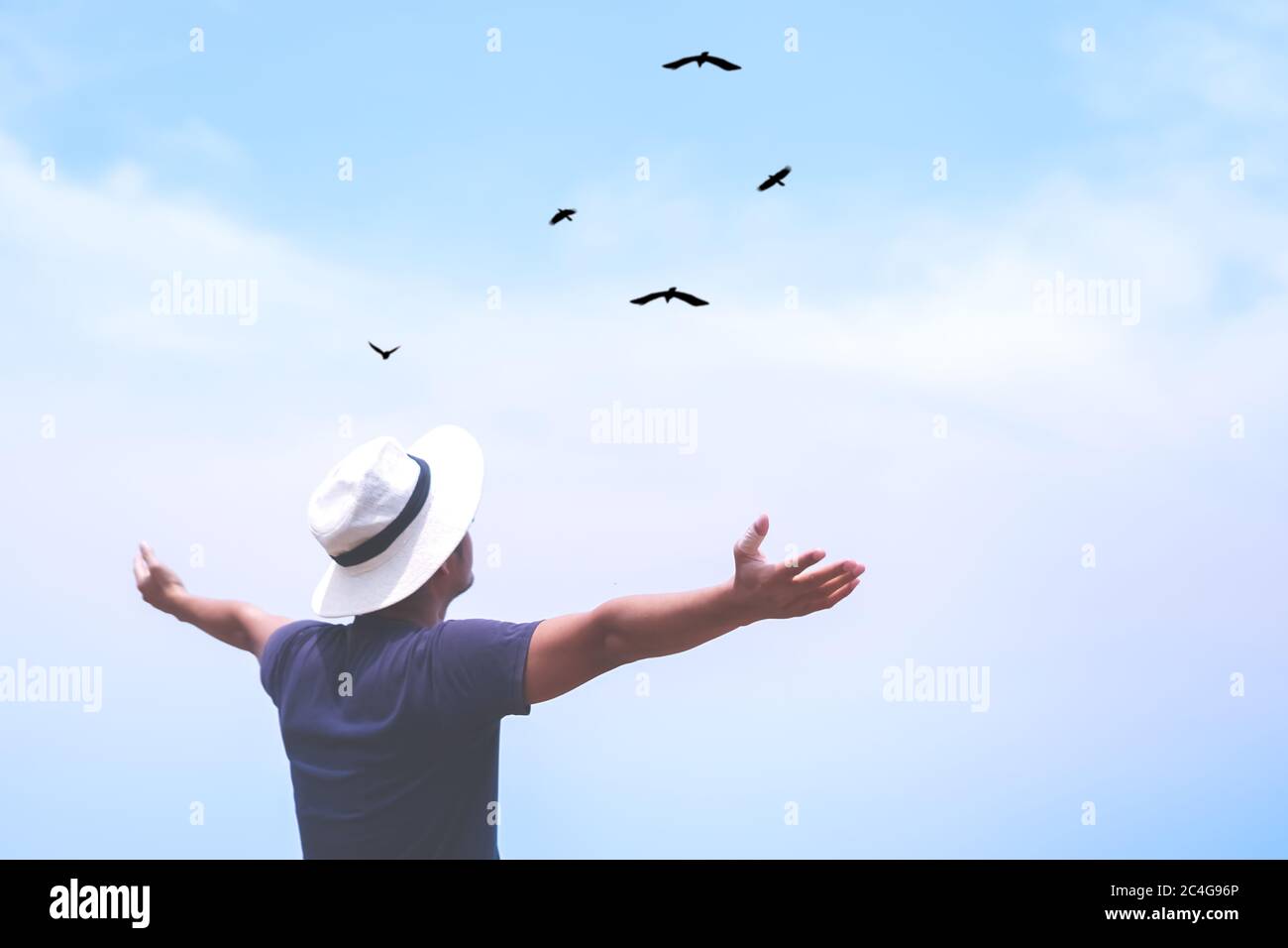 Man rise hands up to sky looking at birds fly through metaphor freedom